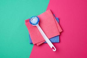 brosse blanche en plastique avec manche et éponges à vaisselle carrées multicolores photo