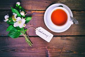 tasse de thé et un bouquet de jasmin en fleurs avec une étiquette en papier photo