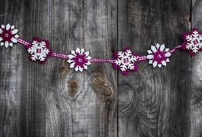 guirlande de flocons de neige en tissu sur une surface en bois gris, tonification vintage photo