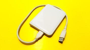 Vieux disque dur externe blanc hdd isolé sur fond jaune photo