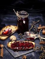 toast avec confiture de framboises et pot de confiture vide avec une cuillère en fer photo