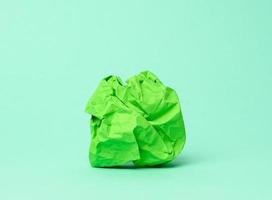 boule de papier vert froissé sur fond vert, photo
