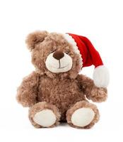 petit ours en peluche marron mignon avec un chapeau de noël rouge est assis photo