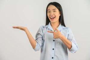 portrait de jeune femme asiatique pointant avec deux mains et doigts sur le côté sur fond blanc isolé photo