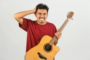 portrait de jeune homme asiatique en t-shirt rouge avec une guitare acoustique isolé sur fond blanc photo