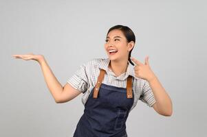 portrait asiatique jeune femme en uniforme de serveuse avec la posture de la paume ouverte photo