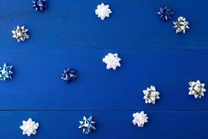 arcs blancs, bleus et gris pour les cadeaux sur un fond en bois bleu photo