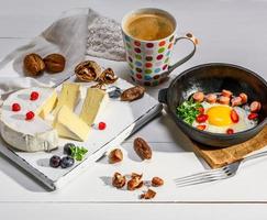 fromage et une poêle ronde en fonte noire avec un œuf de poule frit photo