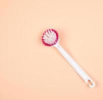 brosse de cuisine avec manche en plastique blanc sur fond beige photo