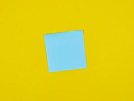 autocollants carrés de papier bleu vide sur fond jaune photo