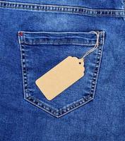 Étiquette de prix vierge en papier brun sur corde contre la poche arrière d'un jean bleu photo