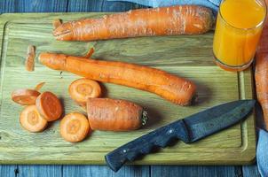 carottes fraîches sur la planche à découper pour le jus de carotte photo