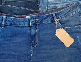 attaché sur une corde est une étiquette de papier brun rectangulaire vide sur un jean bleu photo