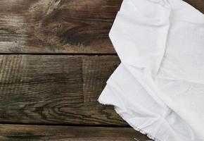 serviette textile de cuisine blanche pliée sur une table en bois grise à partir de vieilles planches photo