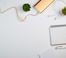 cahier à spirale avec feuilles blanches vides, stylo et plantes vertes photo