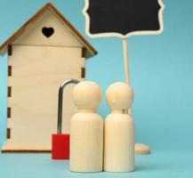 figurines familiales en bois, maison modèle. achat immobilier, concept de location photo