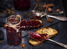 bocal en verre avec de la confiture de framboise et une tranche de pain photo