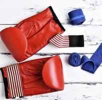 paire de gants de boxe en cuir rouge, bandage bleu photo