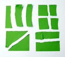 divers morceaux vierges de papier vert sur fond blanc, photo