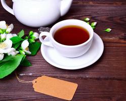 thé noir dans une tasse blanche avec une soucoupe photo