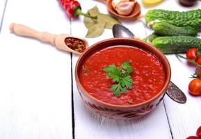 Soupe gaspacho froide dans une assiette en céramique brune photo