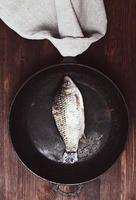 carpe de poisson frais dans une poêle noire photo