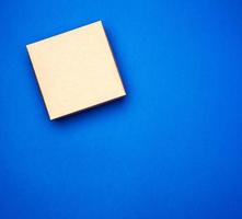 boîte carrée cadeau en carton bleu fermé sur fond bleu foncé photo