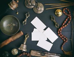 cartes de visite blanches vides au milieu d'objets religieux asiatiques pour la méditation et la médecine alternative photo