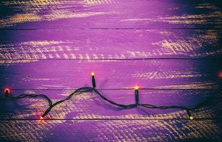 Fond en bois minable lilas avec guirlande électrique photo