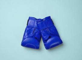 gants de boxe en cuir bleu sur fond bleu. équipement sportif, vue de dessus photo