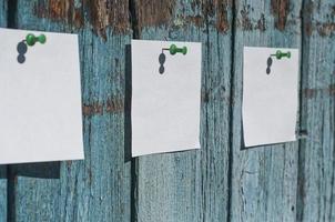 trois feuilles blanches vierges pour vos notes accrochées sur une surface en bois, mise au point sélective photo