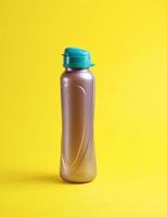 bouteille de sport en plastique fermée sur fond jaune photo