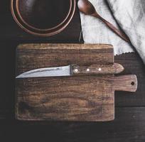 planche à découper brune de cuisine vide avec poignée et couteau photo