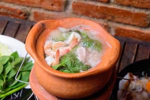 fondue à la thaïlandaise. hot pot avec soupe claire dans la marmite en argile. photo