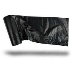 rouleau de sac en plastique noir pour les ordures sur fond blanc photo