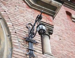 lanterne en fer forgé accrochée au mur d'une maison photo