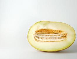 la moitié du melon jaune mûr avec des graines isolées sur fond blanc photo