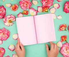 cahier ouvert avec des pages roses vierges sur fond vert photo