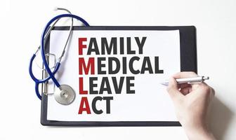 médecin tenant un stylo et une carte avec texte loi sur le congé médical familial, concept médical photo
