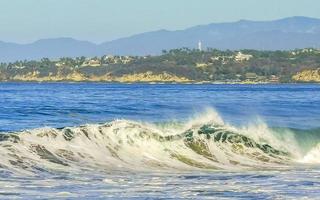 De grosses vagues de surfeurs extrêmement énormes à la plage de puerto escondido au mexique. photo