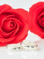 rose rouge et bague de mariage sur blanc photo