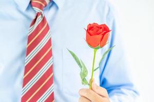 homme tenant une rose rouge à la main sur blanc photo