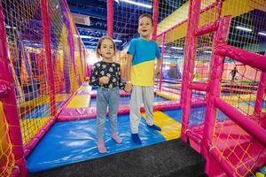 frère avec soeur jouant à l'aire de jeux intérieure du centre de jeux. photo