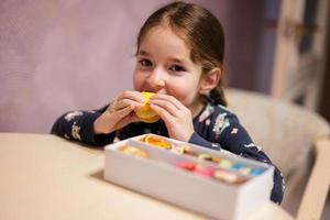 la fille mange un délicieux macaron de couleur douce et savoureuse. photo