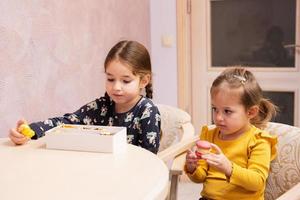 deux soeurs mangent de délicieux macarons aux couleurs douces et savoureuses. photo