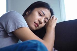 une fille triste assise sur le canapé inquiète et inquiète. photo