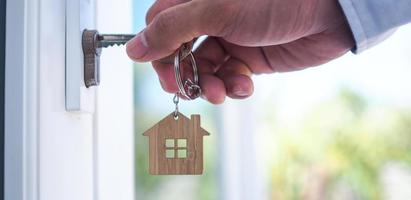 le propriétaire déverrouille la clé de la maison pour une nouvelle maison photo