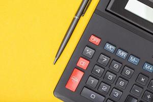 calculatrice et stylo sur fond jaune photo