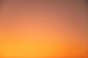 défocalisation du beau ciel orange clair pendant le coucher du soleil. photo