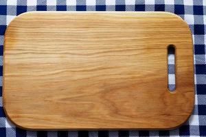 Planche à découper en bois vide sur nappe close-up photo